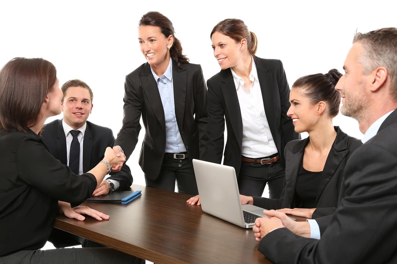 Executives in a coaching conversation around a conference table
